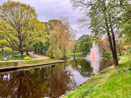 Fountain with evening illumination on Riga city canal that flows through Bastion park Bastejkalns. Riga, capital of Latvia.の写真素材