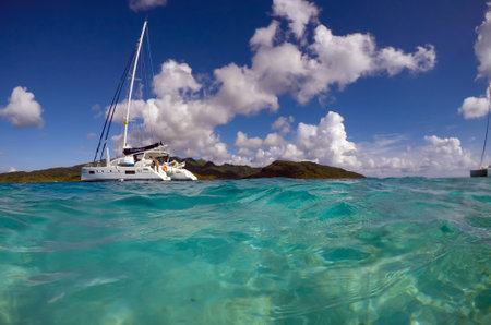FRENCH POLYNESIA, DECEMBER, 2019: Lonely catamaran in a beautiful turquoise lagoon near the island Bora Bora in the Leeward group of the Society Islands of French Polynesia.のeditorial素材
