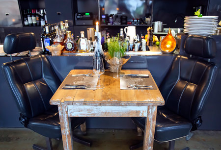 LATVIA, RIGA, JULY, 2022: Modern european small cozy bar interior with vintage wooden table in Riga, Latviaのeditorial素材