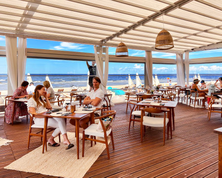 LATVIA, JURMALA, JULY, 2022: Cozy summer wooden veranda of the restaurant on the Baltic Sea coast in Jurmala. The concept of a relaxing holiday.のeditorial素材
