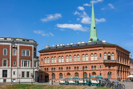 LATVIA, RIGA, AUGUST, 2022: Pleasure electric vehicles and bicycles stand near Riga Stock Exchange building on the Dome Square in Riga Old Town, capital of Latvia. Electric vehicleのeditorial素材