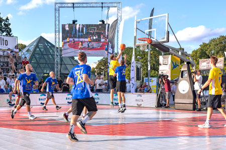 LATVIA, RIGA, AUGUST, 2022: Urban basketball players playing basketball on sports court in Riga, Latvia. Basketball player reaches for the rebound.のeditorial素材