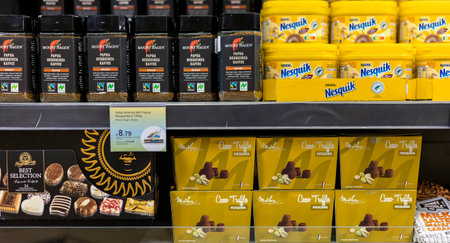 LATVIA, RIGA, AUGUST, 2022: Papua Newguinea instant coffee and Nesquik chocolate drink with  chocolates on the shelf in the shopping mall in Riga, Latviaのeditorial素材