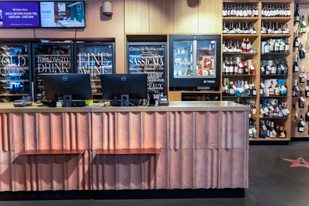 LATVIA, RIGA, AUGUST, 2022: Interior of modern wine boutique store with vintage style wooden showcases and cash desk. Shelves with various of wines from Italian and Spanish vineyarのeditorial素材