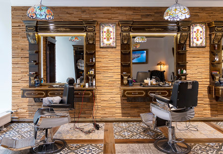 LATVIA, RIGA, OCTOBER, 2022: Modern professional hair salon or barber shop for men in Riga, Latvia.  Inside empty barber shop with mirrors and leather chairs. Clean trendy hairdresのeditorial素材
