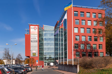Latvia, Riga, October, 2022 - Modern multi storey building with glass walls as a business center for offices and shops surrounded by autumn park in Riga, Latviaのeditorial素材