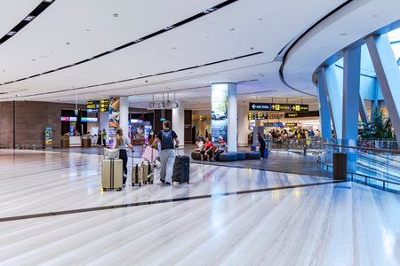 Southeast Asia, Singapore, November, 2022: Passengers with luggage in modern Jewel Changi Airport. Singapore. People walking to airplane. Tourists at international airport.のeditorial素材