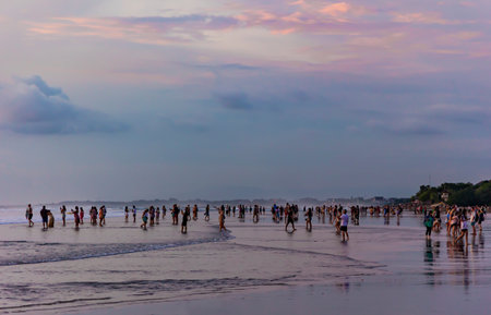 INDONESIA, BALI, NOVEMBER, 2022: People on the beach watching and filming the Balinese colorful sunset over the Indian Ocean in Bali, Indonesia. Nature. Travel concept.のeditorial素材