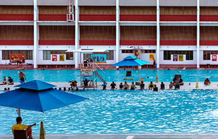 Southeast Asia, Singapore, November, 2022: Public outdoor swimming pool with visitors early morning...