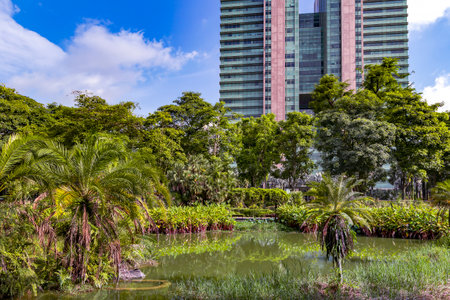 Modern high-rise residential buildings with a beautiful tropical garden on the banks of the city canal in Singapore. Concept of green environment in the city.の写真素材