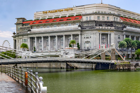 Southeast Asia, Singapore, November, 2022: Cavenagh Bridge next to Fullerton Hotel in Singapore. Fullerton Hotel was converted from an old post office.のeditorial素材