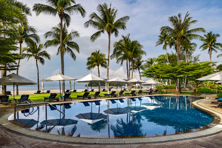 Malaysia, Langkawi, November, 2022: Swimming pool among a beautiful garden with tall palm trees on the territory of Casa del Mar Langkawi hotel, Malaysiaのeditorial素材