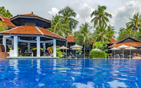 Malaysia, Langkawi, November, 2022: Swimming pool among a beautiful garden with tall palm trees on the territory of Pelangi Beach Resort Spa hotel, Langkawiのeditorial素材