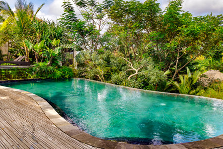 Small swimming pool with clear turquoise water among tropical plants in Ubud, Bali, Indonesia. Scenic place to vacation relax.の写真素材