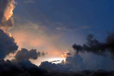 Majestic dramatic sunset sky with large and dark rain clouds in evening time over the tropical region in Ubud, Indonesia. Stormy cloudy sky.の写真素材