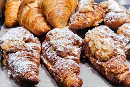 Homemade Almond Croissants freshly baked and cooling on rack. Traditional French breakfast with gold and crispy croissants.の写真素材