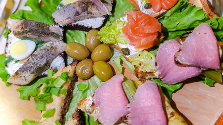 Open sandwiches with salted salmon, cream cheese and marinated herring with quail eggs on lettuce leaves. Morning healthy breakfast with fish. Quick and Healthy Sandwiches.の写真素材