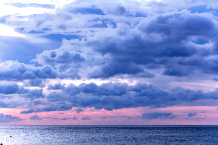 Majestic dramatic sunset sky with large and dark rain clouds in evening time over the Andaman Sea in Langkawi island, Malaysiaの写真素材