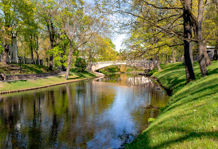 Stone bridge over Riga river canal in Riga central city park at sunny spring day, capital of Latvia.の写真素材