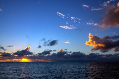 Beautiful sunset near the Bora Bora island on the Pacific ocean in the Leeward group of the Society Islands of French Polynesia. Tranquil relaxing sunlight summer vibes.の写真素材