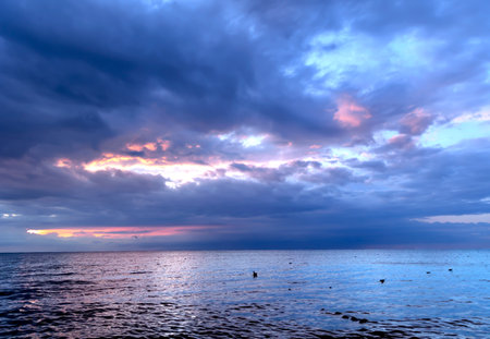 Sunset on the Baltic Sea. Dramatic sky with glowing clouds.の写真素材
