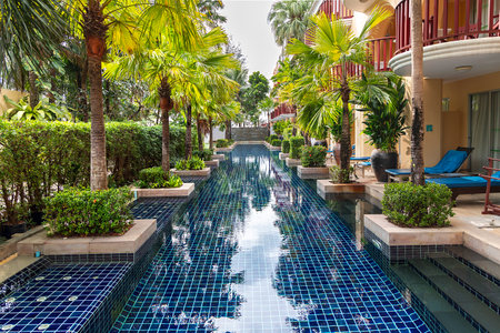 Swimming pool in luxury hotel resort with palm trees and swimming poolの写真素材