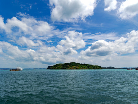 Small forested islands against a background of blue sky with cumulus clouds in the quiet Andaman Sea in Thailand. The beauty of a clean environment in Asia.の写真素材