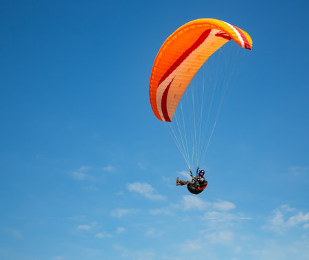 Paraglider flying in the blue sky on a sunny dayの写真素材