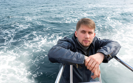 Portrait of young man on board a yacht in the Baltic Sea, Riga. Latvia. Concept of a short holiday on the water. Relaxed Man.の写真素材