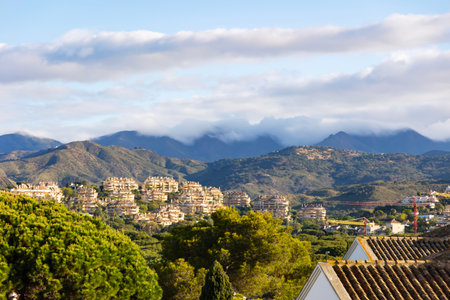 Rain clouds on the Pyrenees mountains and a beautiful landscape with blooming pine trees in Elviria,...