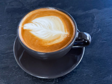 A cup of coffee latte top view with microfoam milk leaf shape foam.の写真素材
