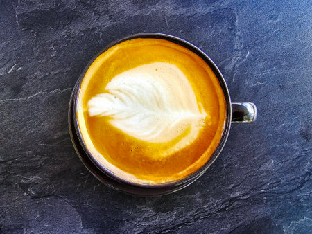 A cup of coffee latte top view with microfoam milk leaf shape foam.の写真素材