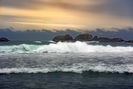 Big foamy waves of the Indian Ocean at Turtle Beach with huge boulders in the distance at sunset in Sri Lankaの写真素材