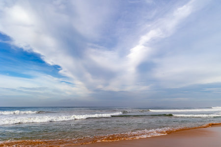 Beautiful landscape with blue sky and soft cirrus clouds over calm Indian Ocean with small foamy waves in Sri Lanka, Asiaの写真素材