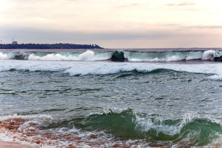 Panorama of natural Indian Ocean with big foamy waves crashing on sandy shore. Sri Lanka. Asia