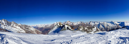 Beautiful winter panorama of snow-capped peaks of the Swiss Alps with clean mountain air on a sunny day in Saas Fee, Switzerland.の写真素材