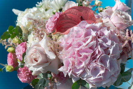 Summer bouquet of pink hydrangeas, roses and calla lilies close up on a blue backgroundの写真素材