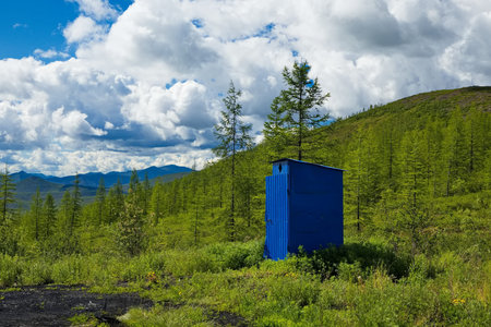 Blue cabin on the background of coniferous forest. Yakutia, Russia