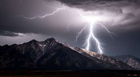 A powerful and awe-inspiring long exposure shot of a lightning storm over a mountain range. The image captures the dynamic movement of lightning in bright whites against a backdrop of dark grays, ideal for commercial use to evoke intensity and nature's grandeur.の素材