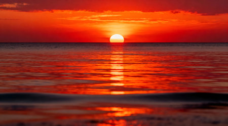 A stunning horizontal photograph capturing a vibrant sunset over a serene ocean. The image features dramatic fiery orange and red hues, creating an inspiring mood. Ideal for commercial use in travel and nature-themed projects.の素材