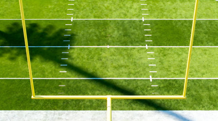 This illustration showcases a meticulously detailed football field under bright daylight, featuring lush green grass and crisp white yard lines. The field is adorned with vibrant team colors, including bold stripes of red and blue along the sidelines, enhancing the energetic atmosphere of a sports event. Ideal for use in sports-themed graphics, game day promotions, or as a backdrop for sports-related content. AI-generated illustration.の素材