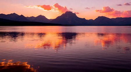 This image captures a tranquil lake at sunset, bathed in the golden hour's warm orange and pink tones. The serene water reflects the vibrant sky, creating a peaceful and artistic landscape. Ideal for use in nature-themed decor, relaxation spaces, or as a backdrop for personal reflection. AI-generated illustration.の素材