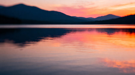 This image captures a tranquil lake at sunset, bathed in the soft glow of golden hour. The water reflects vivid shades of orange and delicate pinks, creating a peaceful ambiance. The artistic composition is ideal for enhancing the visual appeal of nature-themed websites or as a calming backdrop for meditation and relaxation spaces. AI-generated illustration.の素材