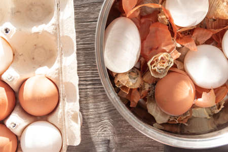 Prepare to paint the egg for Easter. Onion husks, egg and towel are on a wooden tableの写真素材