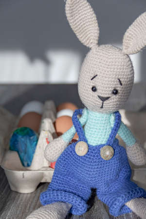 The Easter Bunny is on a wooden surface with painted eggs.の写真素材