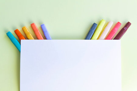 A lot of colorful felt-tip pens for drawing in a notebook and album on a yellow background.の写真素材