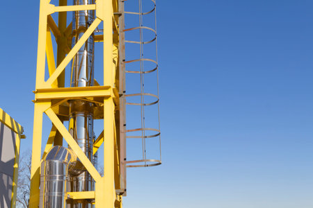 A new, yellow, working boiler room outside on a bright sunny day. Modern fuel and environmental...