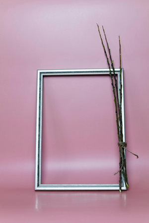The willow and frame stands near the pink wall