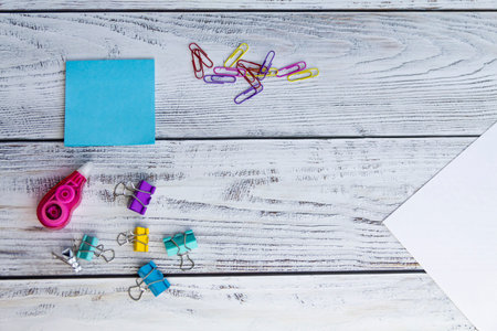 Blue sheets for notes, colored paper clips, a sheet of white paper, paper clips and a proofreader...