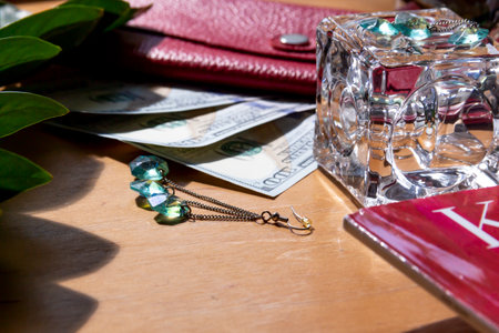 American dollars and a red genuine leather wallet on a wooden surface with fashion magazines and sunglasses.,,の写真素材